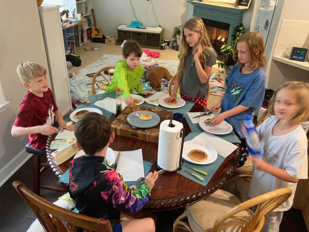 A bunch of children having pancakes