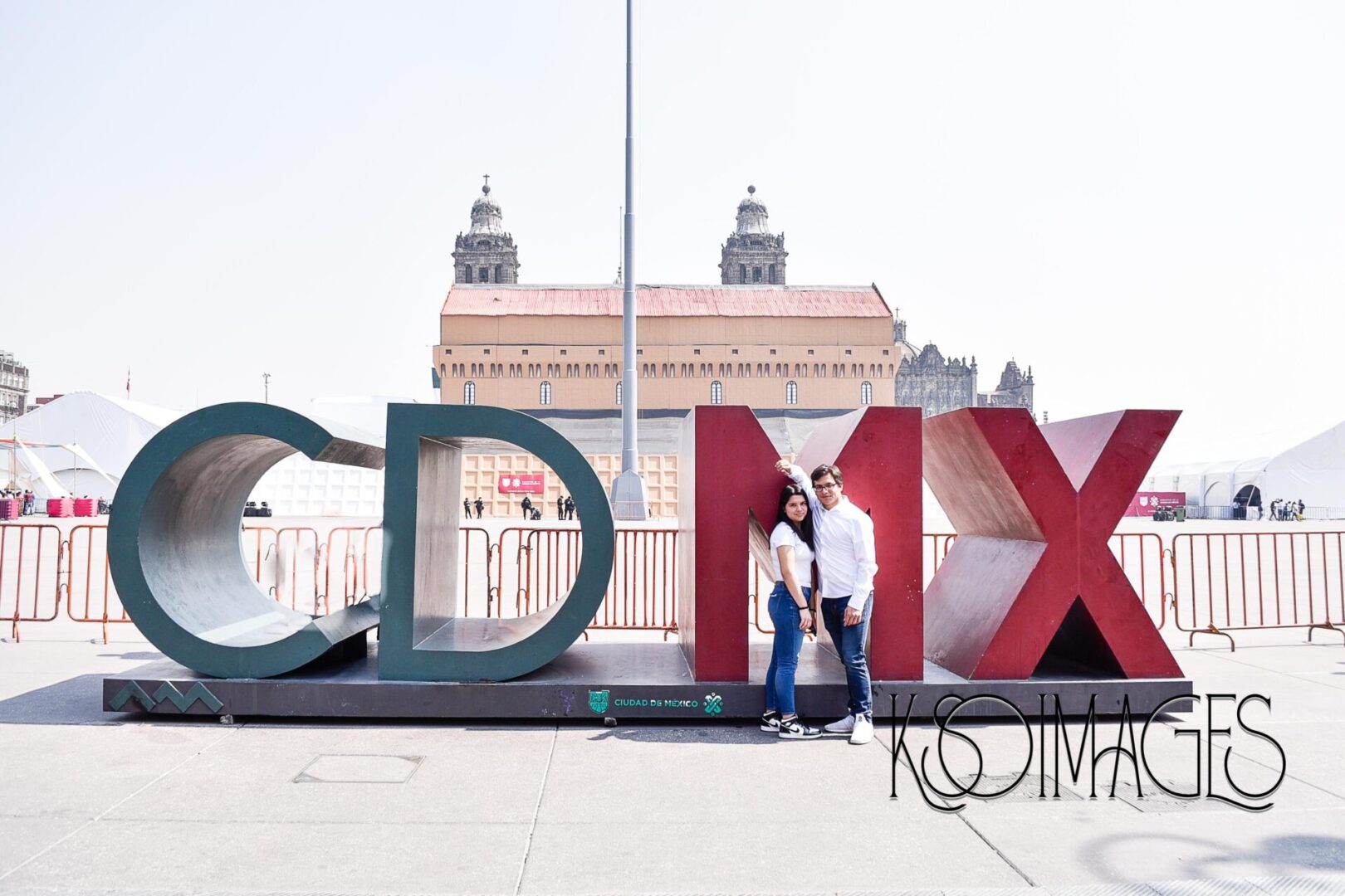 A man and woman posing in front of a “CDMX” sculpture