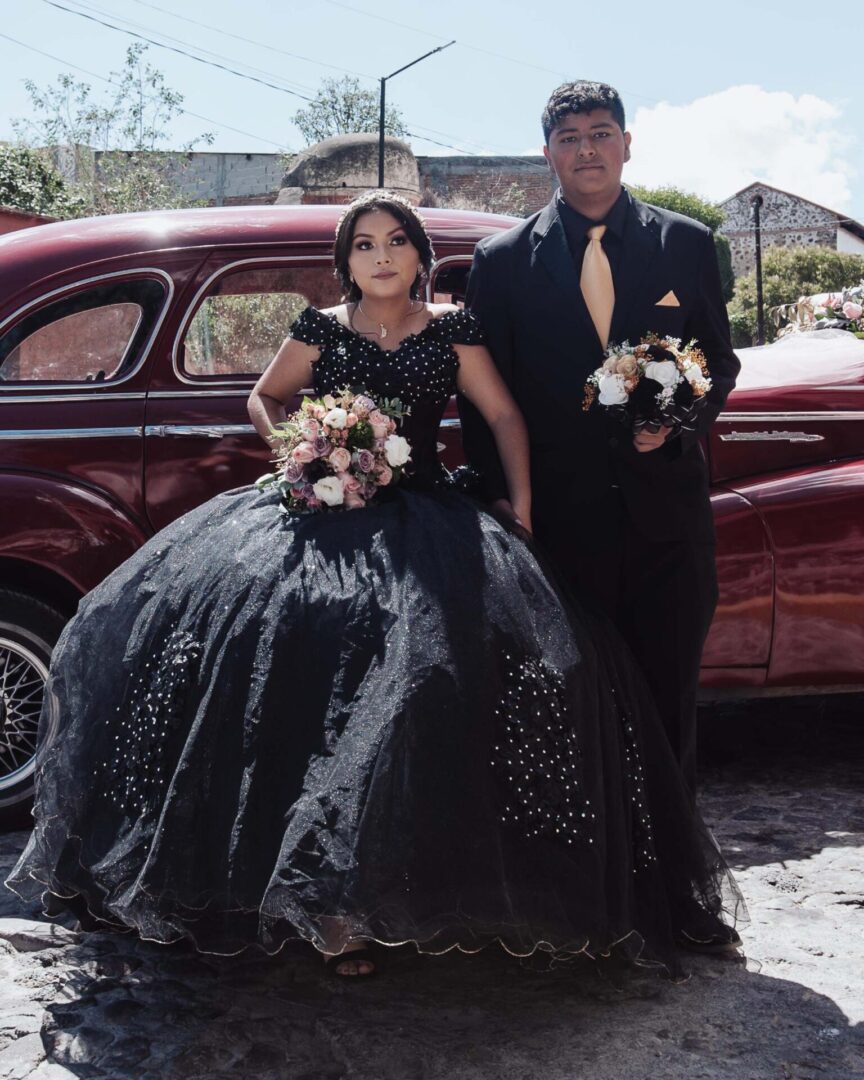 A young lady and young man holding a bouquet