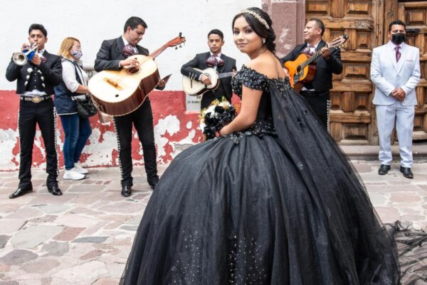 A mariachi band and a young lady in a black gown