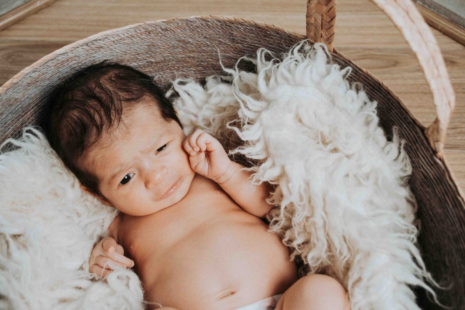 An infant lying on a white, fluffy cloth