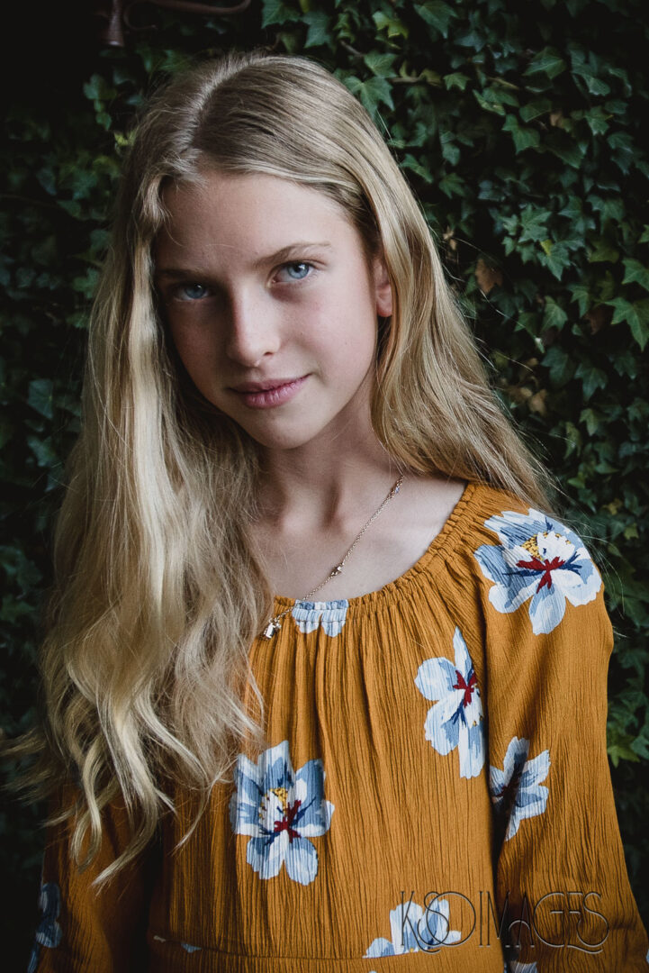 A young blonde girl wearing a floral dress