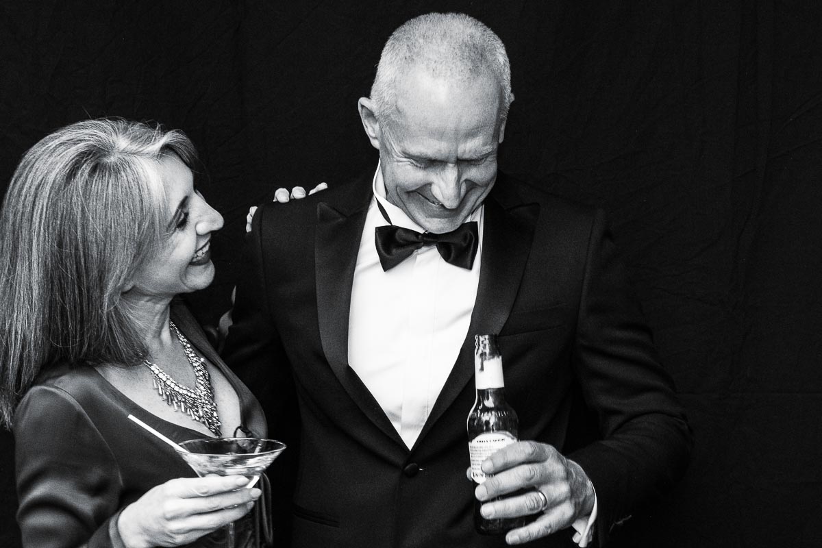 A man and woman dressed in formal wear holding drinks