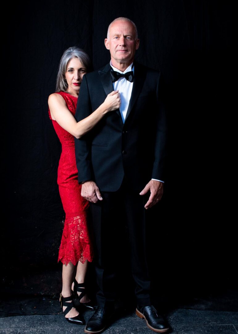 A man in a black suit and a woman in a red dress