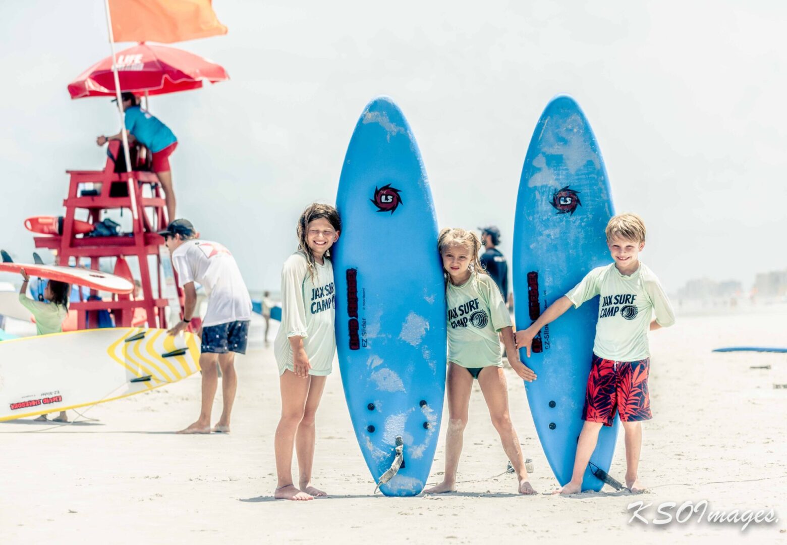 Three kid surfers on the beach