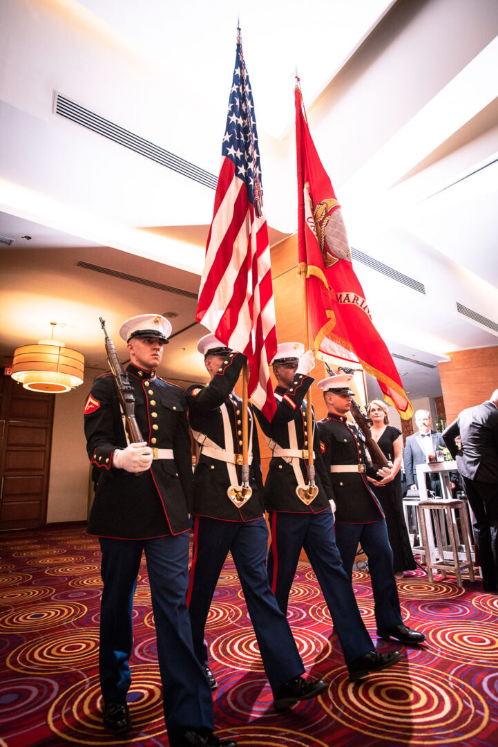 Four men in uniform marching